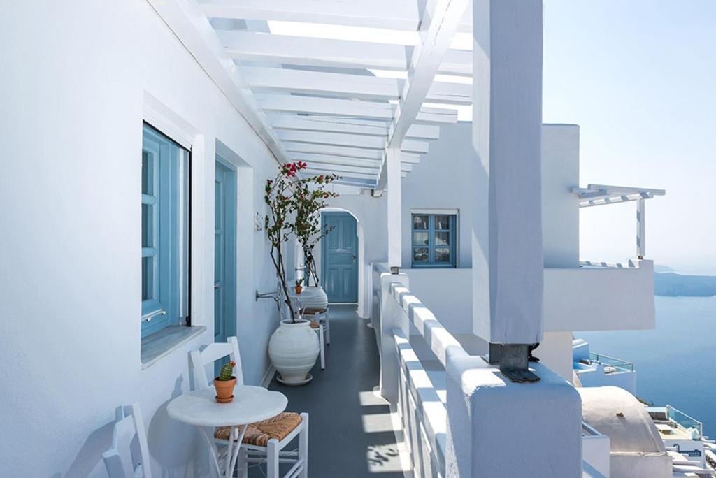 a white balcony with a view of the water at Helestia Hotel, Caldera Santorini in Firostefani