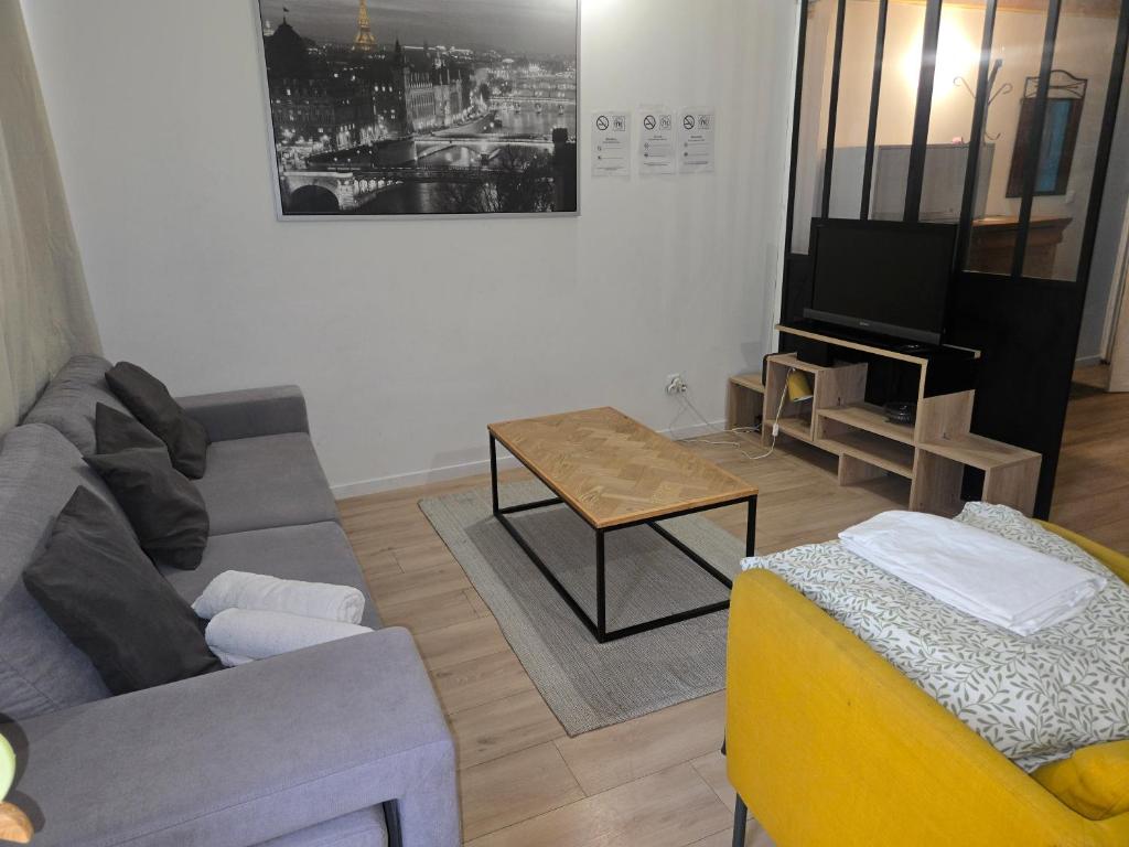 a living room with a couch and a table at La mezzanine Rouennaise in Rouen