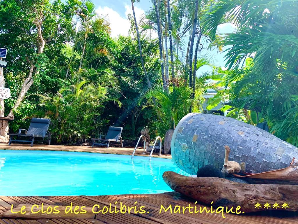 a statue of a boat next to a swimming pool at LODGE PAMPLEMOUSSE avec PISCINE privative , dans parc calme à 500 m plage in Le Carbet