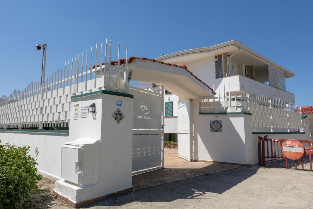 a small white house with a gate and a building at Villa Giglio Marino in Paestum