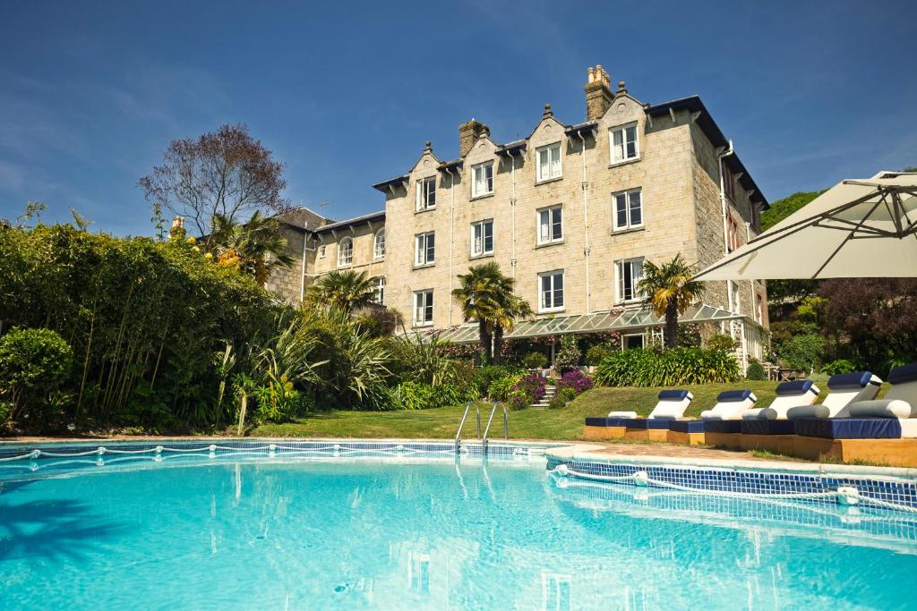 a large building with a swimming pool in front of a building at The Royal Hotel in Ventnor