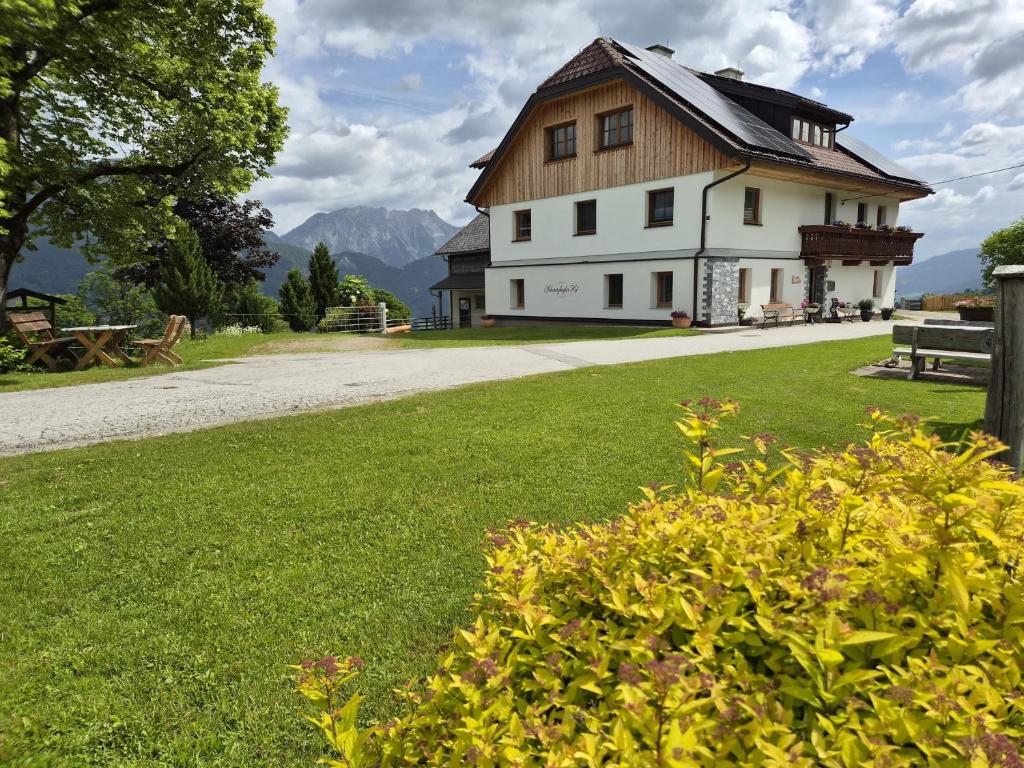 a large white house with a wooden roof at Appartement Schwarzkoglerhof in Haus im Ennstal