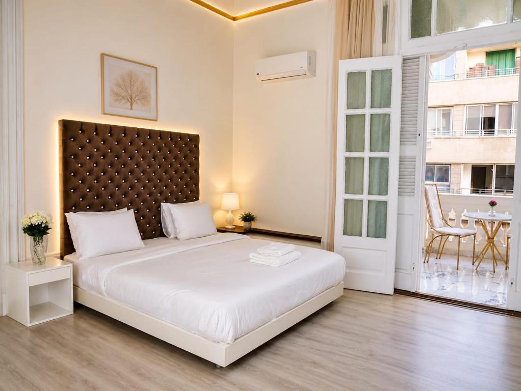 a bedroom with a large white bed and a table at Qasr court in Cairo