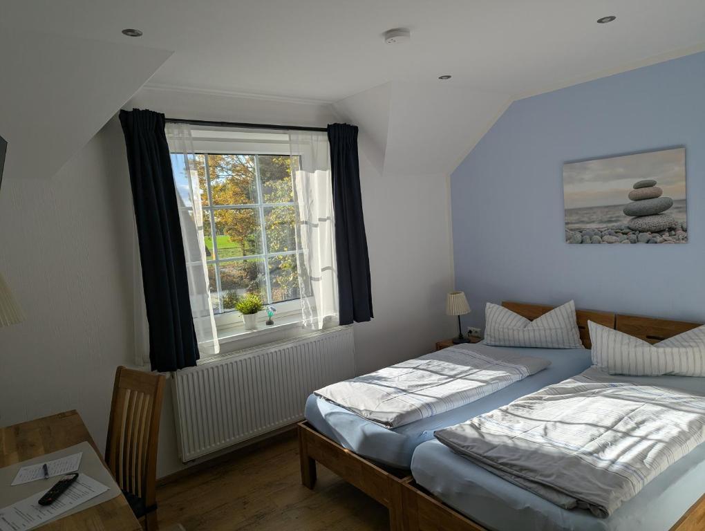 a bedroom with two beds and a window at Pröve Hof in Eicklingen
