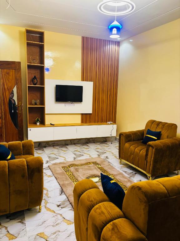 a living room with two couches and a flat screen tv at Villa Diamaguene in Ngaparou