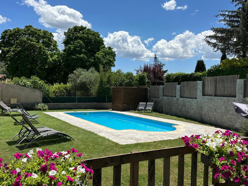 a swimming pool in a yard with flowers at Hotel Rural Covarrubias in Covarrubias