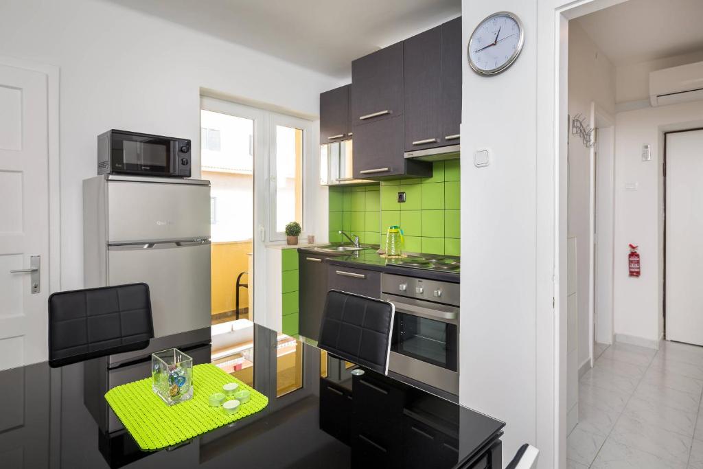 a kitchen with a table and a clock on a wall at APARTMENT "Patricia" in Split