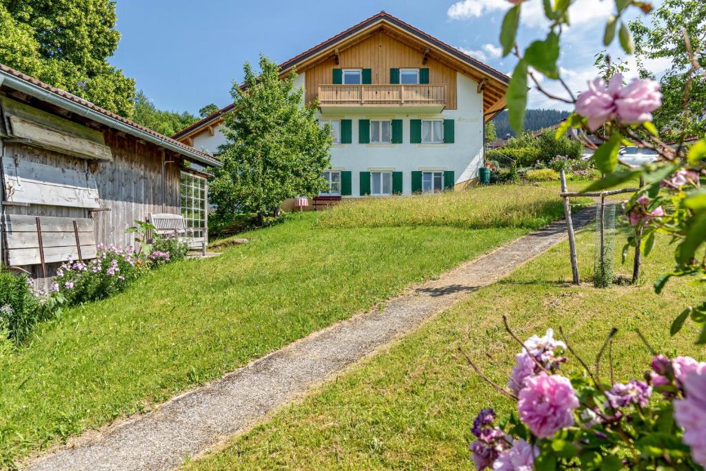 a house on a hill with flowers in the yard at Ferienwohnung Panorama Bad Kohlgrub in Bad Kohlgrub