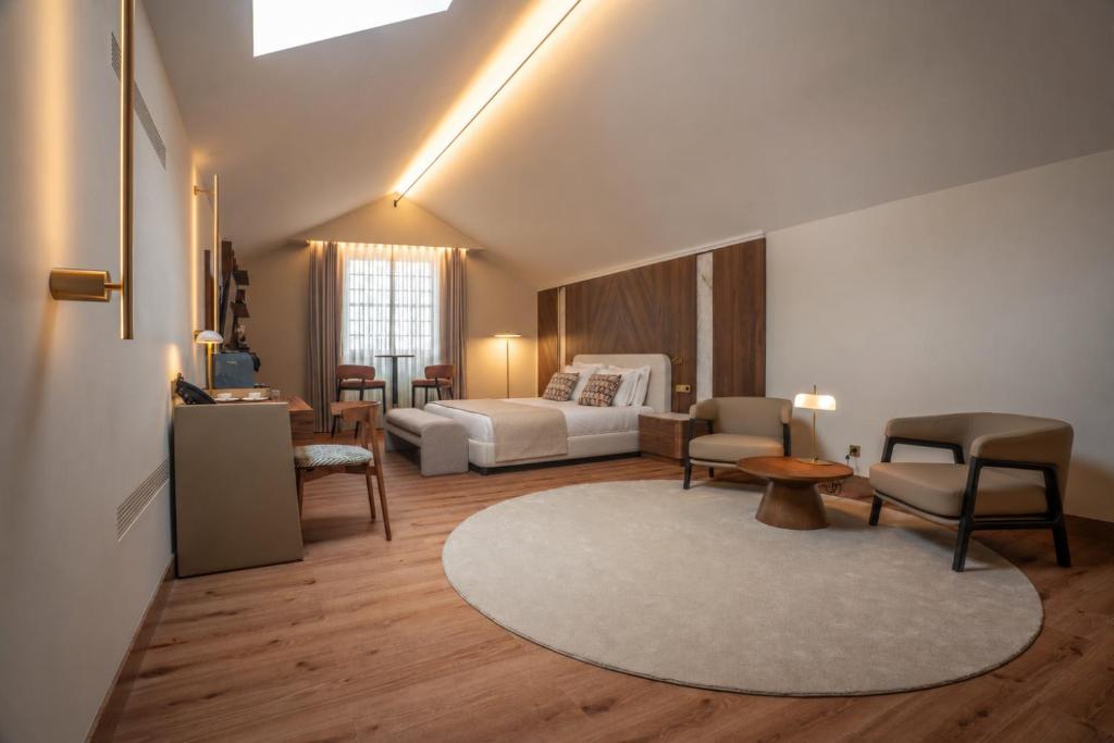 a living room with a bed and a table and chairs at The Book Hotel in Horta