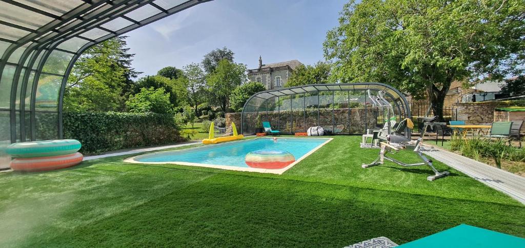 a backyard with a swimming pool and a playground at Le Figuier , Domaine La Capitainerie in Bazoges-en-Pareds