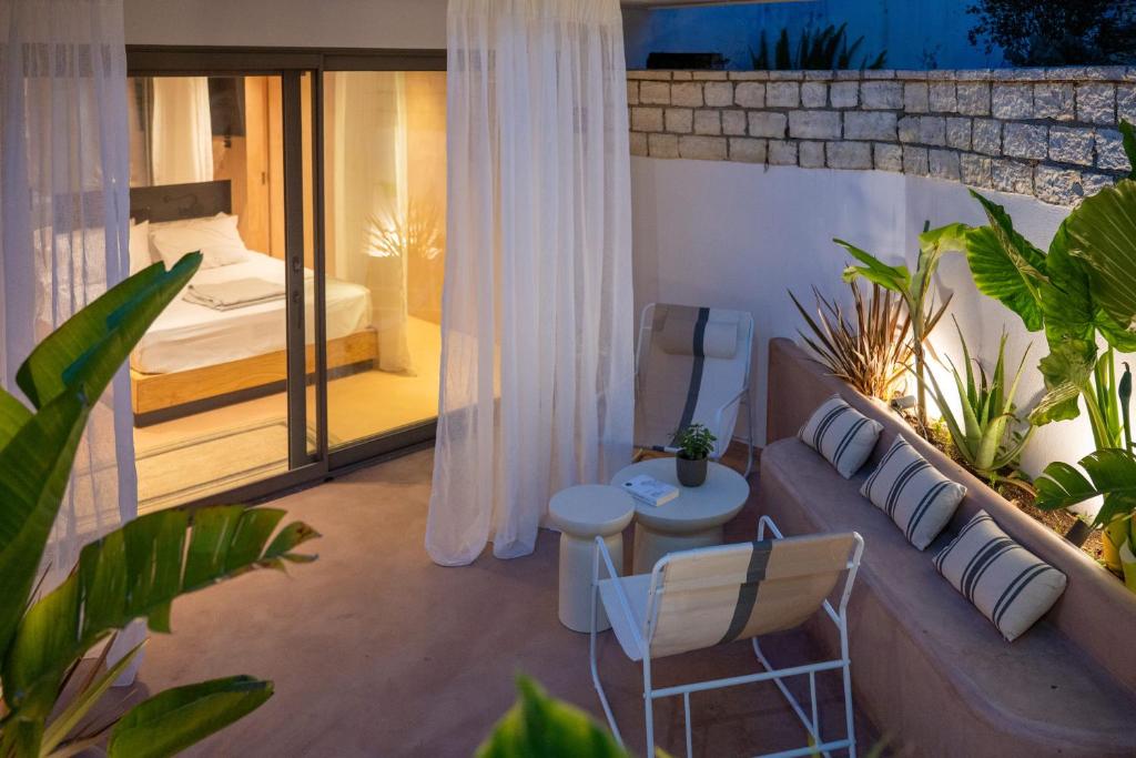 a room with a couch and a bed on a balcony at Nest In The Yard in Parga