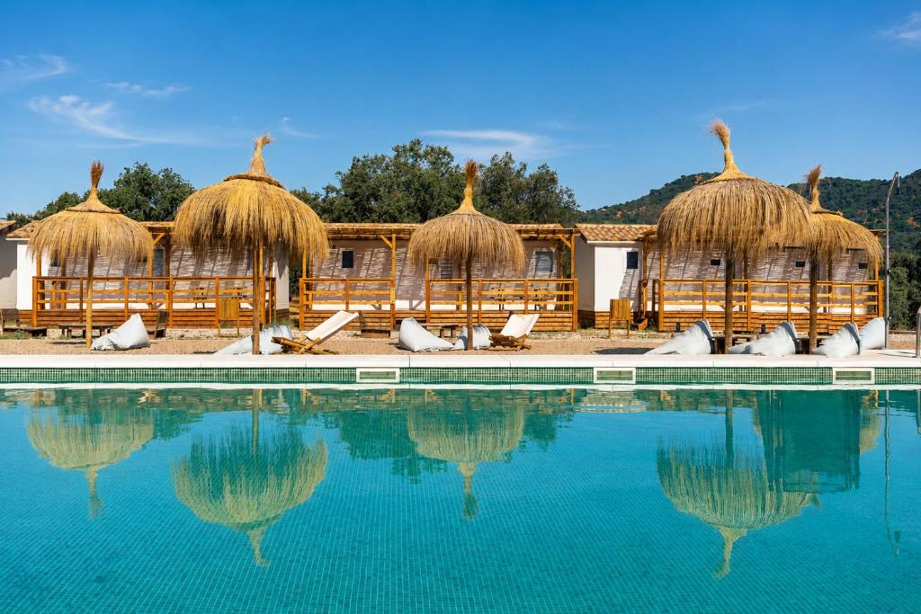 a swimming pool with some chairs and some water at Kampaoh El Pedroso in El Pedroso