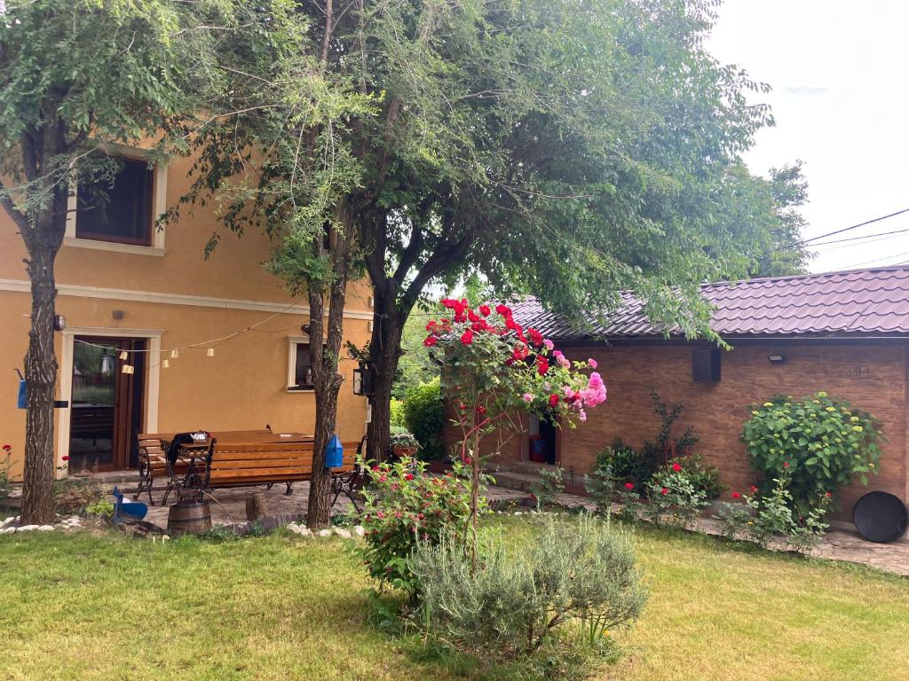 a house with a bench and flowers in the yard at Vila Damjanka Banja Vrujci in Popadić