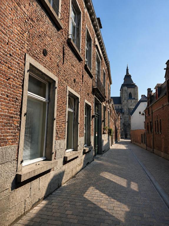 an empty street with a brick building and a church at Villa Theresa à 25 min de PAIRI DAIZA in Soignies