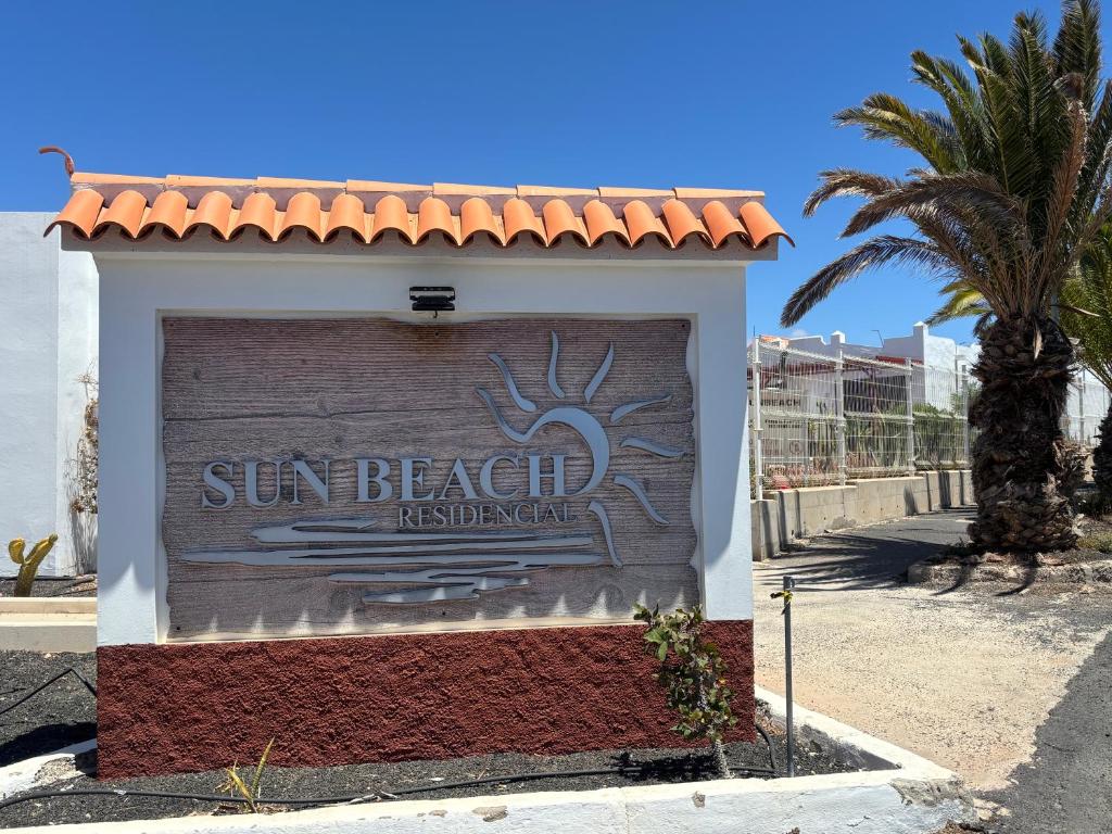 a sign for sun beach restaurant on the side of a building at Apartamento tranquilo Sun Beach in Caleta De Fuste