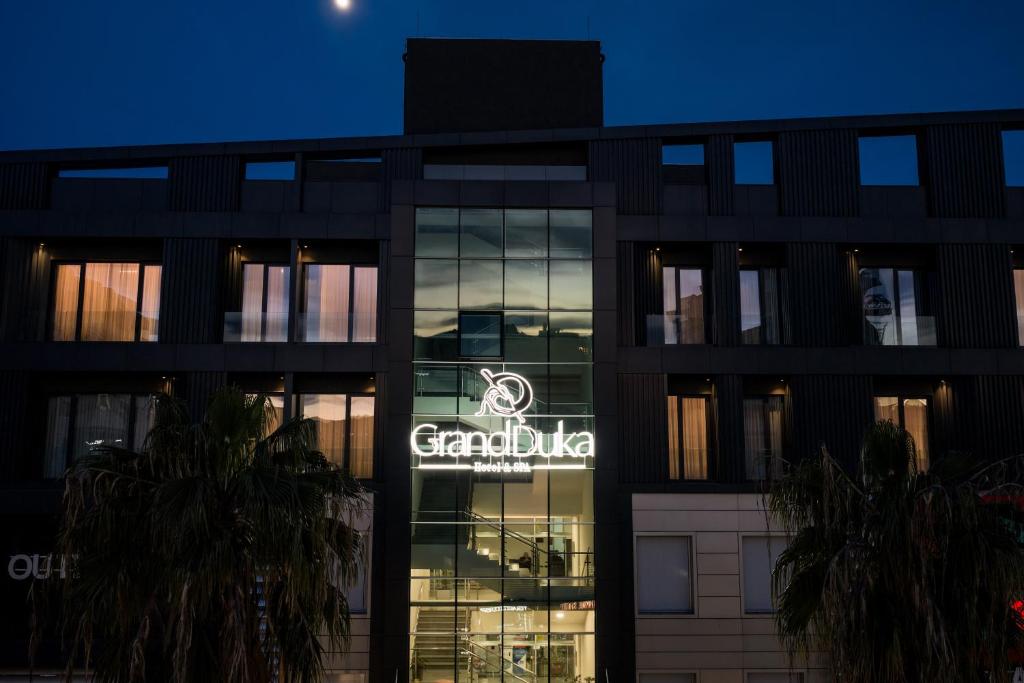 a building with a sign on the side of it at Grand Duka Hotel & SPA in Durrës