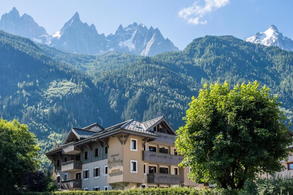 a building with mountains in the background at Résidence Pierre & Vacances Premium La Ginabelle in Chamonix