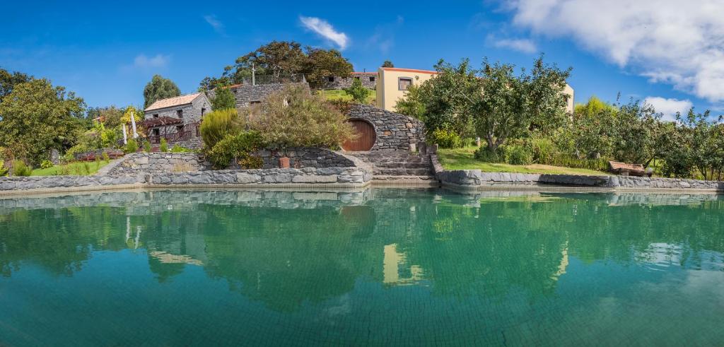 a large body of water with a building in the background at Casas da Levada in Ponta do Pargo