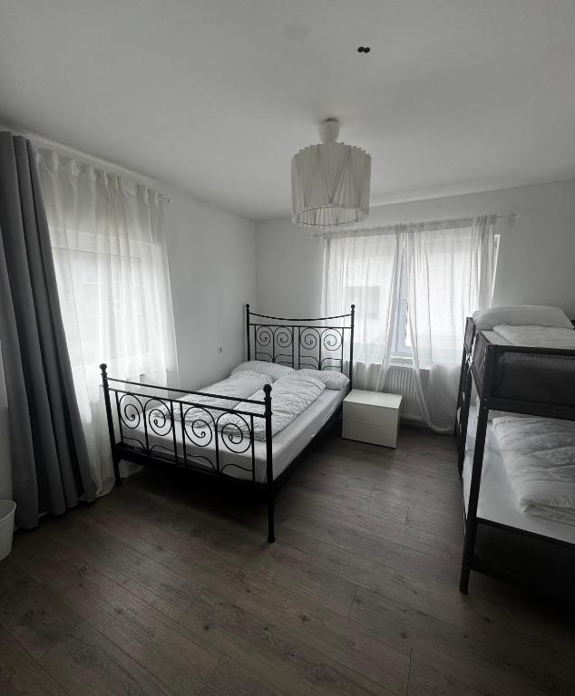 a bedroom with two beds and two windows at Gästehaus OG in Cologne