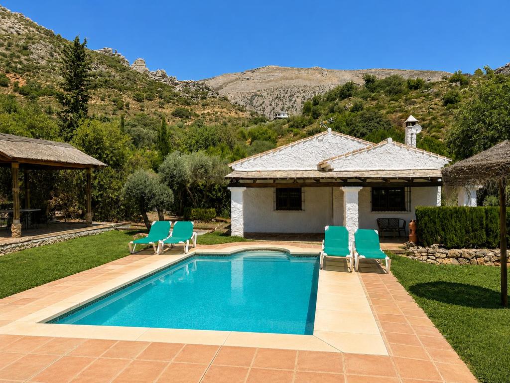 a swimming pool with chairs and a house at Villa La Clavelina Rocabella in El Chorro