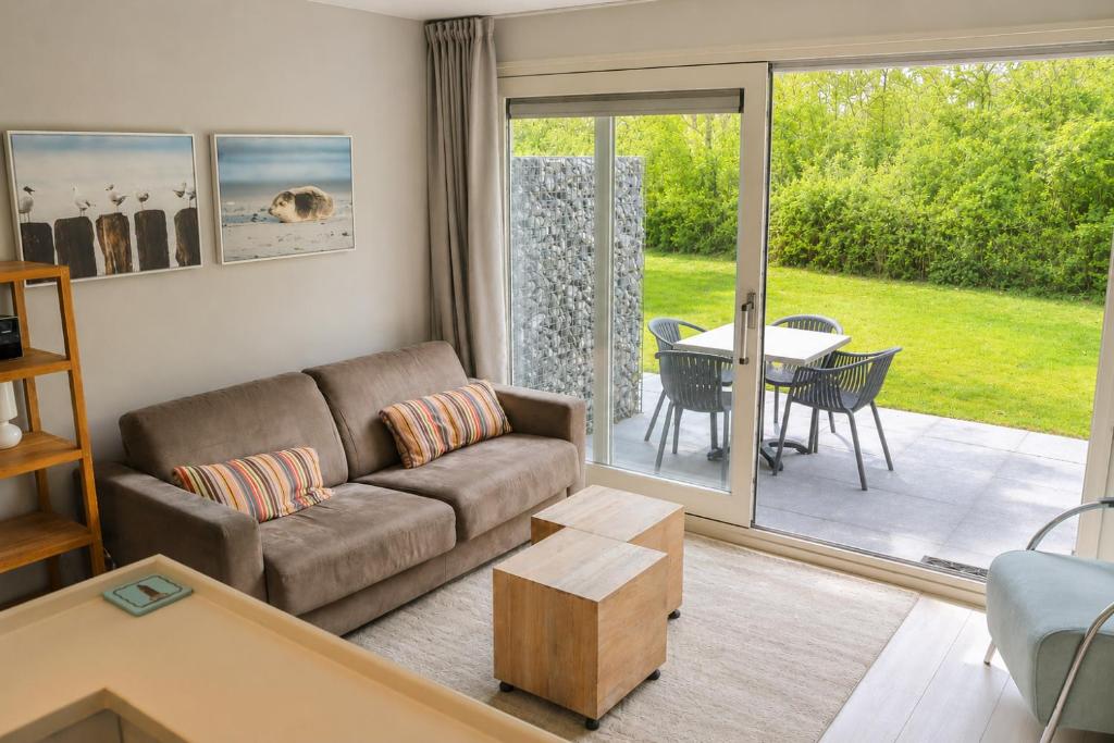 a living room with a couch and a table at Appartement De Noordkaap in Hollum