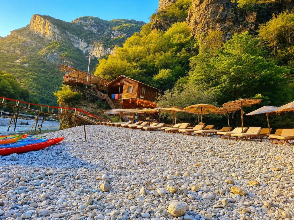 a group of chairs and umbrellas on a rocky beach at Captain's House in Mollʼ e Shoshit