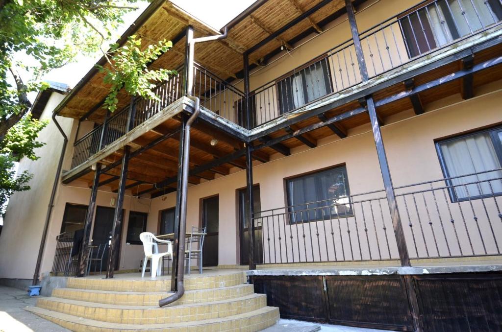 a building with stairs and a chair in front of it at Vila Flora Costinesti in Costinesti