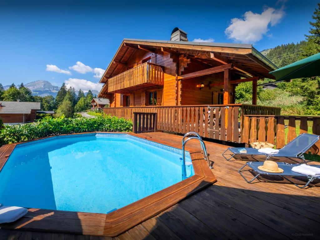 a pool on a deck with a log house at Chalet Igel - OVO Network in Châtel
