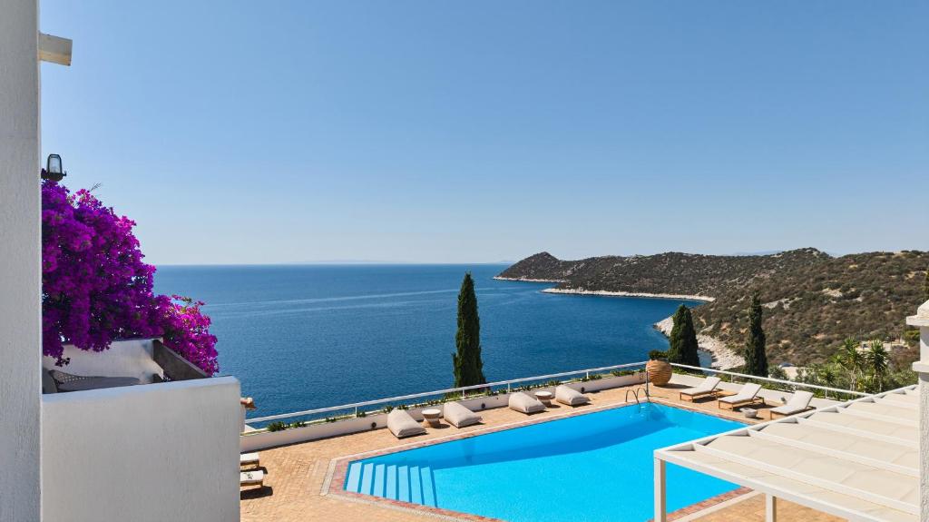 a swimming pool with chairs and a view of the ocean at Villa Artisti Marathon in Marathon