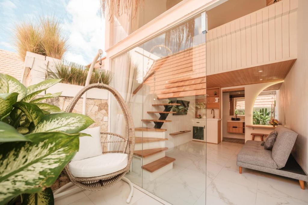 a living room with a wicker chair and stairs at Santai Studios in Badung