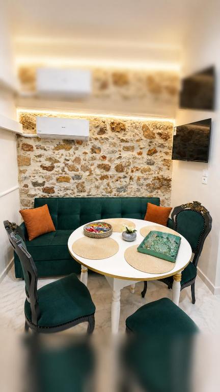 a living room with a table and a green couch at Chalikas Vintage Cottage in Mytilene