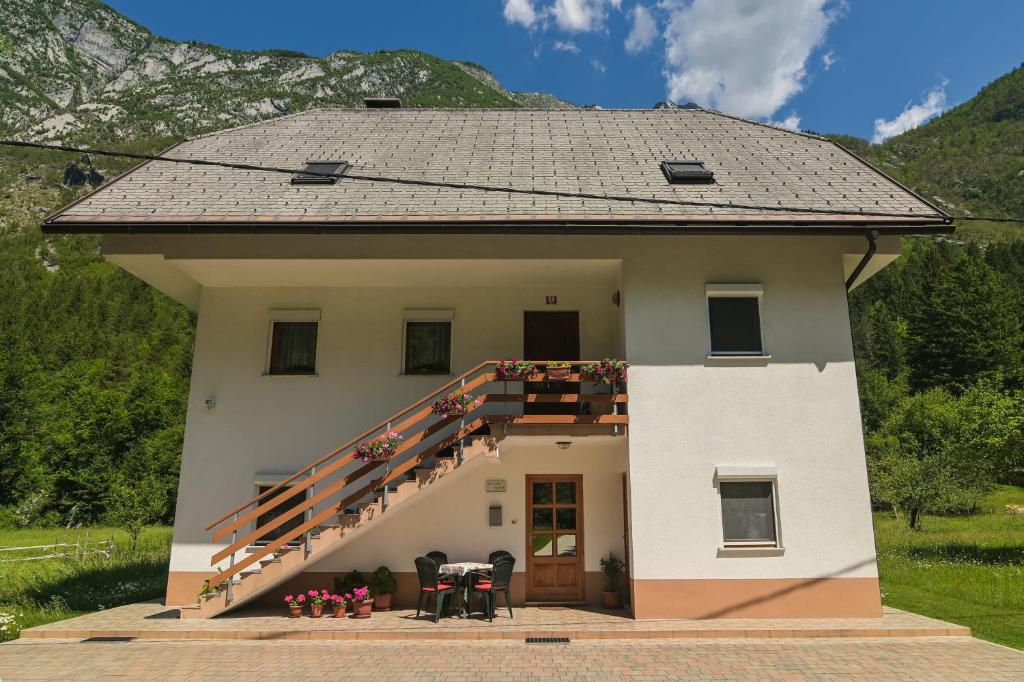a house with a staircase on the side of it at Apartma pod Rožem in Soča