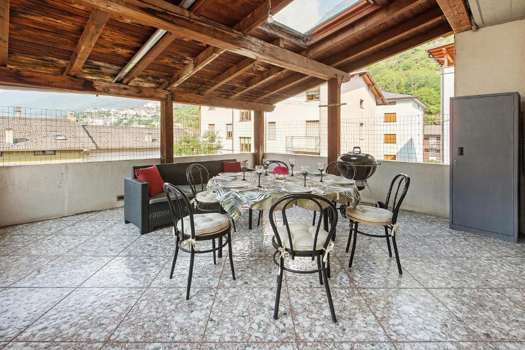 a dining room with a table and chairs on a patio at Terrazza Valtellina in Grosio