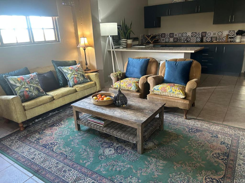 a living room with two couches and a coffee table at Mariri Farm Cottage in Patentie