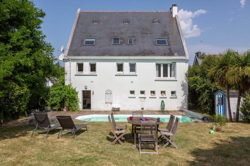 a house with a table and chairs and a pool at La parenthèse Océane -Avec piscine in Concarneau