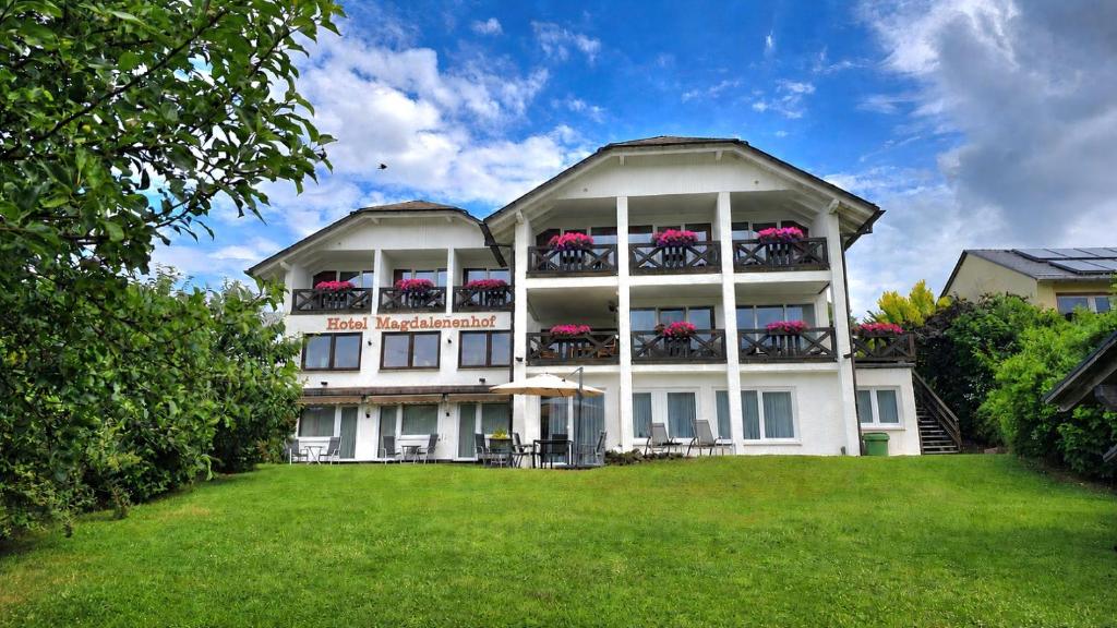 a large white building with flowers on the balconies at Hotel Magdalenenhof inklusive MeineCardPlus in Willingen