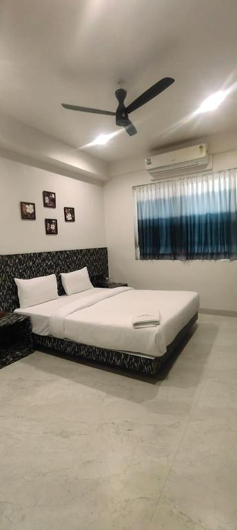 a bedroom with a large bed with a ceiling fan at Hotel Jay Palace Inn in Solapur