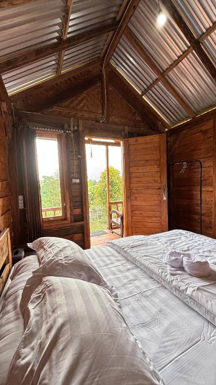 a large white bed in a room with a window at Kuna GlampCamp in Gitgit
