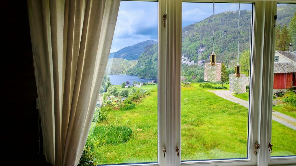 a window with a view of a mountain at Romantic farmhouse in Vaksdal