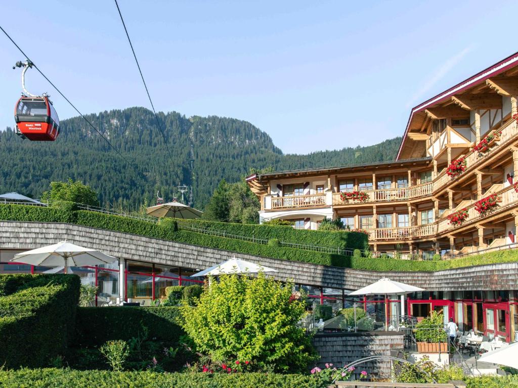 a hotel with a red cable car in front of it at Hotel Kaiserhof Kitzbühel, 4 Sterne Superior in Kitzbühel