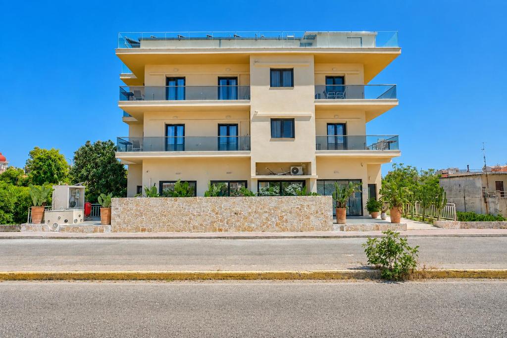 a large yellow building on the side of a street at Sunflower Suites Gouvia Corfu in Gouvia
