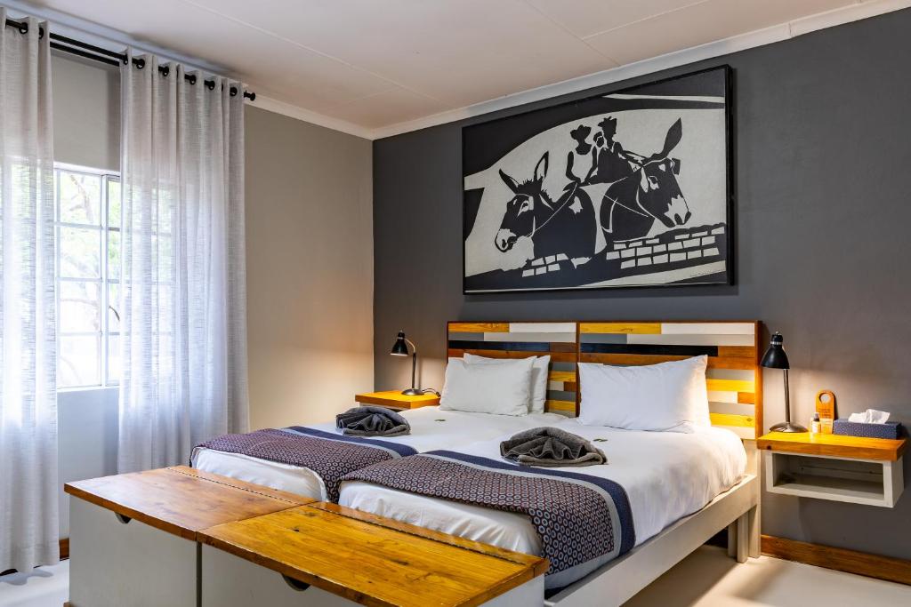 a bedroom with a bed and a picture of a horse on the wall at Gondwana Damara Mopane Lodge in Mopane Pos