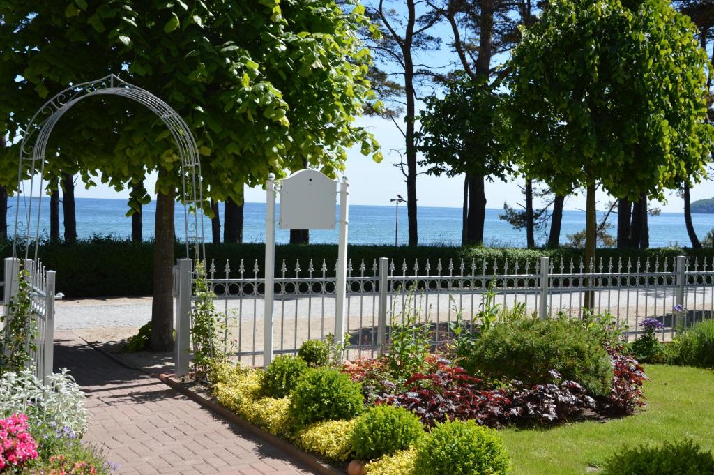 a white fence with a garden and flowers at Villa Steinfurth direkt am Strand in Binz in Binz