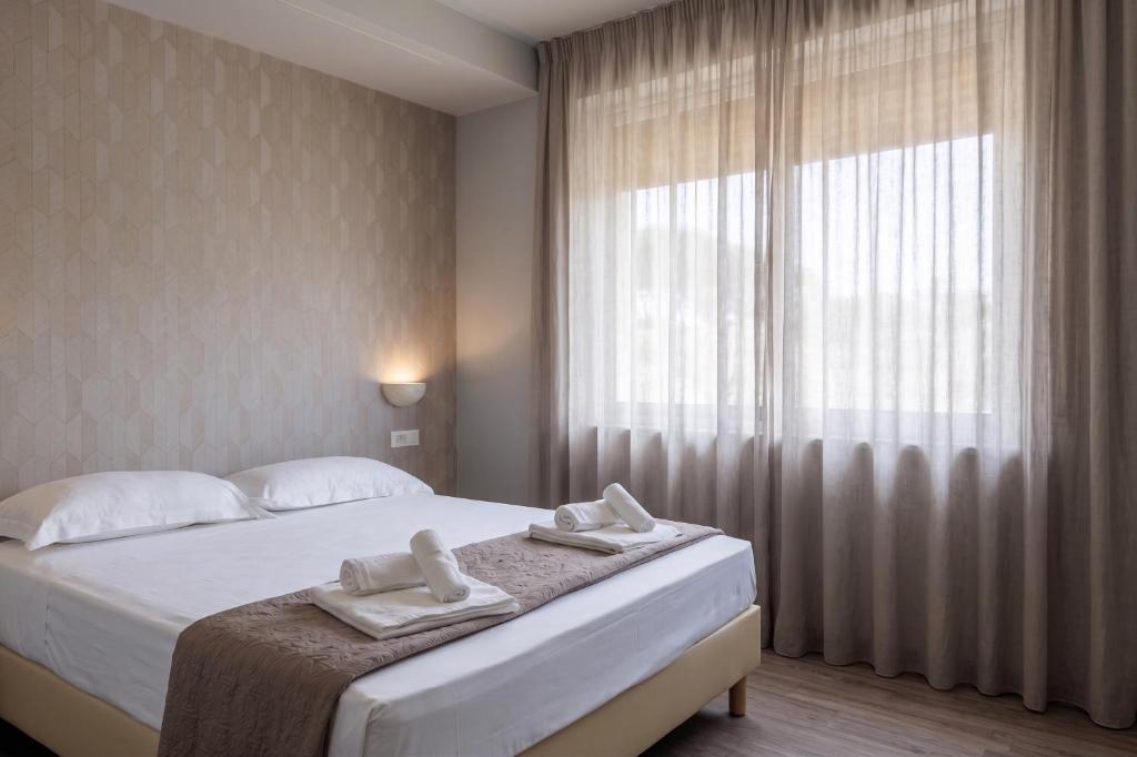a bedroom with a bed with two towels on it at La Palazzata Urban Suites in Messina
