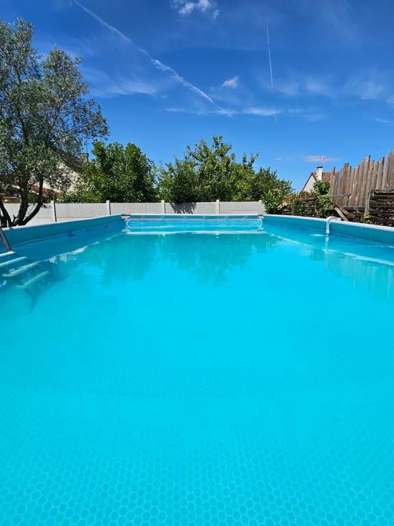 a large swimming pool with blue water at Appartement T2 confortable - ParisGetAway95 in Pierrelaye