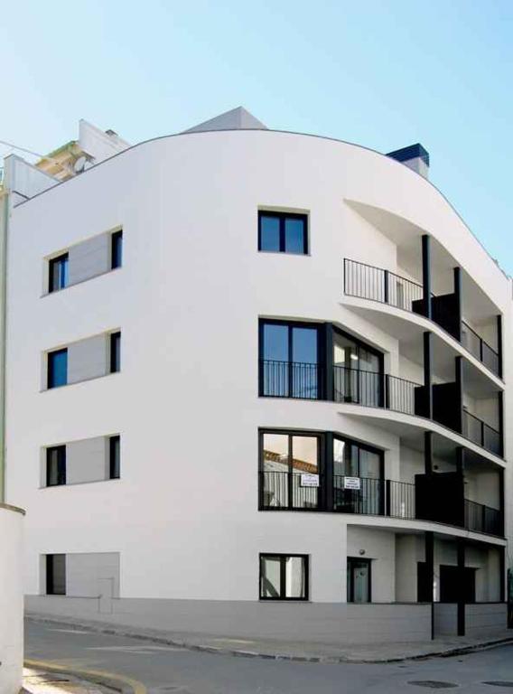 a white building withwindows and balconies on the side of it at Apartamentos TDM in Tossa de Mar