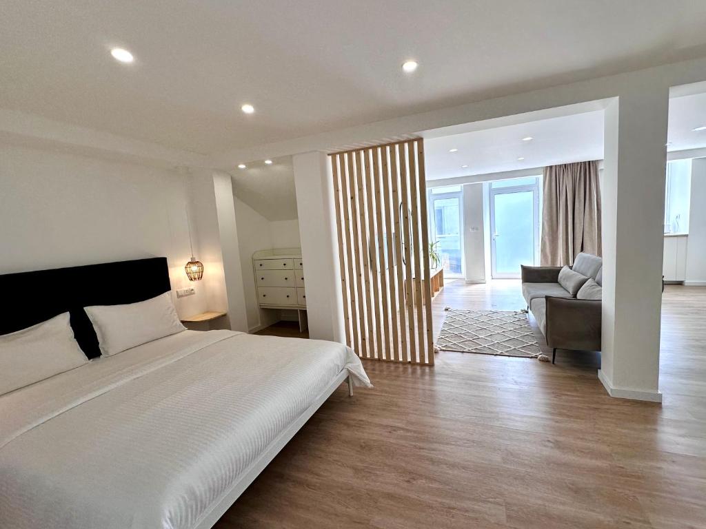 a bedroom with a bed and a living room with a couch at UpTown Apartments in Horta