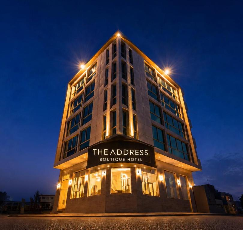 a tall building with a sign on it at night at The Address Boutique Hotel Karachi in Karachi