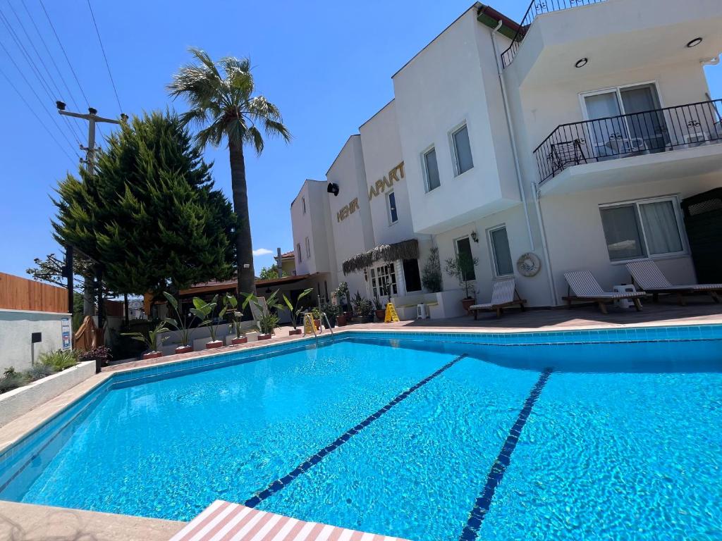 a swimming pool in front of a building at Nehir Apart Hotel in Fethiye