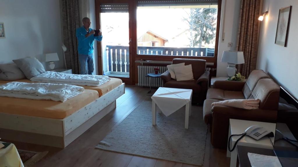 a man standing in a room with a living room at Ferienwohnung Ritter in Missen-Wilhams